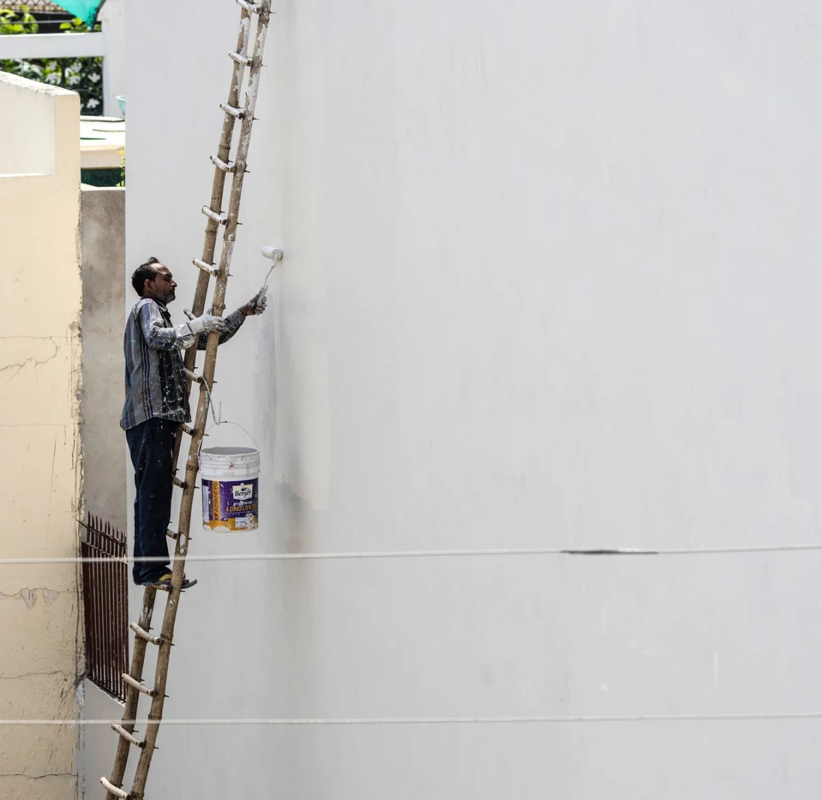 Schilder aan het werk aan de buitenzijde van een woning